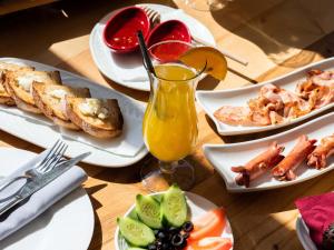 a table with plates of food and a glass of orange juice at La Brisa Boutique Hotel in Dhërmi