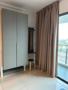 Habitación con armario y silla junto a una ventana en Evo Soho en Bandar Baru Bangi