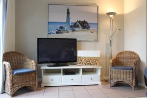 a living room with a television and two chairs at Kustverhuur, Vakantiepark Fort Soleil 60 in Breskens