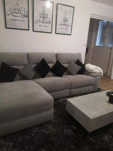 a living room with a couch and a coffee table at Appartement proche aéroport Beauvais-tille in Beauvais