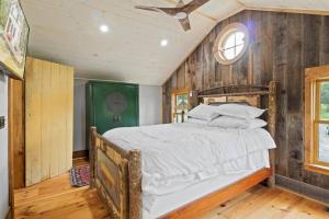 a bedroom with a bed in a room with wooden walls at Cozy Two Bedroom Home On Canandaigua Lake in Rushville
