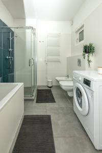 a white bathroom with a washing machine in it at Lovag 12 Terrace Apartment in Budapest