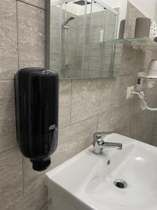 um lavatório de casa de banho com um dispensador de sabão na parede em Garibaldi guest house em Nápoles