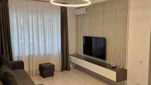 Regie Rezidence في بوخارست: غرفة معيشة مع تلفزيون بشاشة مسطحة على جدار