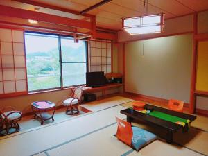 a room with a room with a table and chairs at 御宿しんしま in Matsuzaki