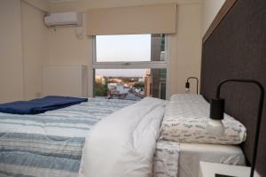 1 dormitorio con 1 cama grande y ventana en Departamentos T&M en Santiago del Estero