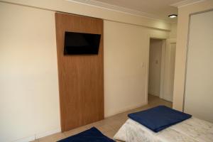1 dormitorio con 1 cama y TV en la pared en Departamentos T&M en Santiago del Estero