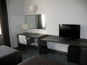 a room with a desk with a television and a mirror at Park Hotel Sporting in Teramo