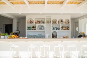 a bar with white stools in a room at Ostuni a Mare in Ostuni