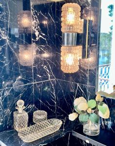 a bathroom with a black tiled wall with lights at Villa Billerud in Säffle