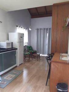 eine Küche und ein Wohnzimmer mit Kühlschrank und Tisch in der Unterkunft Stúdio Natureza S/A 2 in Bombinhas