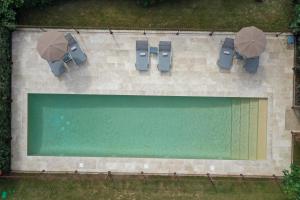an overhead view of a swimming pool with chairs and umbrellas at Chateau de Drudas in Drudas