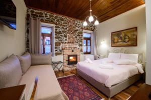 a bedroom with a bed and a living room with a fireplace at Agios Germanos in Agios Germanos