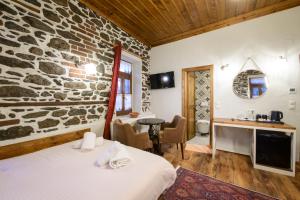 a room with two beds and a stone wall at Agios Germanos in Agios Germanos