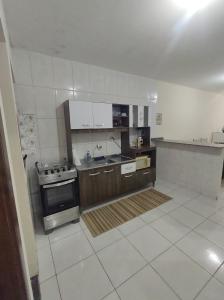 a large kitchen with a stove and a sink at Casa Aconchegante em Itapema in Itapema