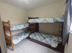 two bunk beds in a room with a window at Casa Aconchegante em Itapema in Itapema