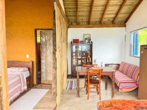 Cette chambre comprend une table, un canapé et un lit. dans l'établissement Chalé com vista para o mar, à Ilhabela