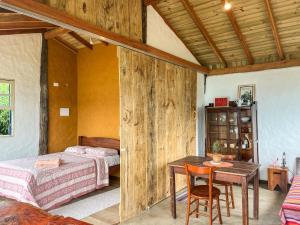 a bedroom with two beds and a table and chairs at Chalé com vista para o mar in Ilhabela