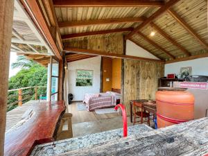 a living room with a bed and a table at Chalé com vista para o mar in Ilhabela