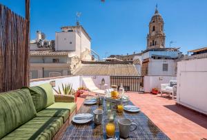 patio con sofá y mesa en el balcón en Solaga - Siglo, en Málaga