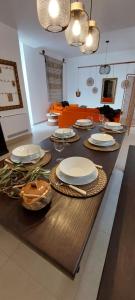 a table with plates and dishes on top of it at PugliaMia Casa, terrasse vue mer, 3 chambres, 2 salles d'eau in Carovigno