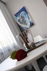 a red rose sitting on a table next to a lamp at Park Hotel Sporting in Teramo