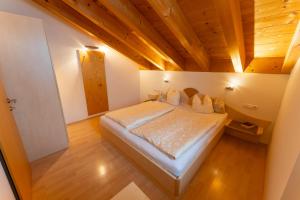 ein Schlafzimmer mit einem großen Bett und einer Holzdecke in der Unterkunft Haus Montana in Damüls