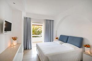 sypialnia z białym łóżkiem i oknem w obiekcie Ostuni a Mare w mieście Ostuni