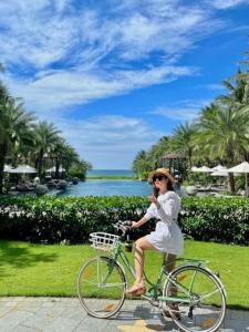 uma mulher num vestido branco a andar de bicicleta em Phu Quoc villa in Marina Resort beach swimming pool em Phu Quoc