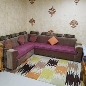a living room with a purple couch in a room at العين الهيلي مصباح بيت 8 in Al Ain
