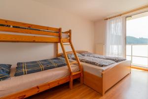 a bedroom with two bunk beds and a window at Residence Le Mont in Trutnov