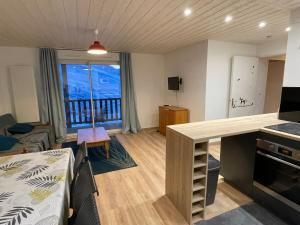 a kitchen and living room with a view of a balcony at T3cab-Peyragudes-61m2-8pers in Germ