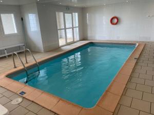 a large swimming pool with blue water in a room at T3cab-Peyragudes-61m2-8pers in Germ