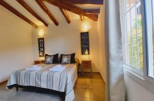 a bedroom with a bed and a large window at La Isolina Chacras, jardín, parrilla y naturaleza! in Chacras de Coria