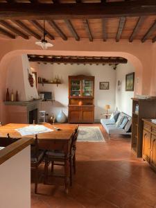 eine Küche und ein Wohnzimmer mit einem Holztisch in der Unterkunft Il Glicine in Bucine