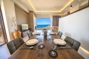 a dining room with a table and a view of the ocean at Golden View Luxury Villa Platanias in Plataniás