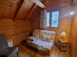 a living room with a couch in a log cabin at Chalet cosy 6 pers avec SPA, terrasse sud, proche station ski, animaux admis - FR-1-393-16 in Saint-Michel-de-Chaillol