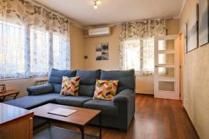 貝薩盧的住宿－Can Camps Besalú Alojamiento con jardín privado，客厅配有蓝色的沙发和桌子