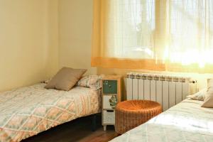 a bedroom with two beds and a window at Can Camps Besalú Alojamiento con jardín privado in Besalú