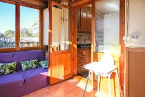 uma sala de estar com um sofá roxo e uma mesa em Can Camps Besalú Alojamiento con jardín privado em Besalú