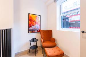 a living room with a chair and a window at The Maida Vale in London