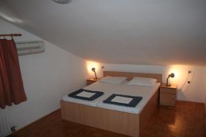 um quarto com uma cama com dois candeeiros em Guesthouse Jelić em Biograd na Moru