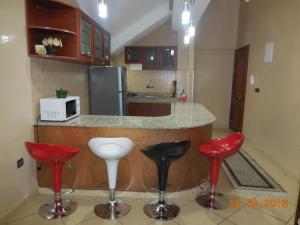 uma cozinha com bancos vermelhos e pretos em frente a um balcão em Bel Appartement à Ifrane em Ifrane
