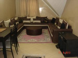 - un salon avec un canapé et une table dans l'établissement Bel Appartement à Ifrane, à Ifrane