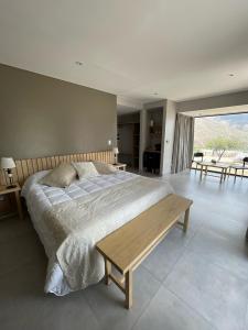 um quarto com uma cama grande e uma mesa de madeira em La Morada em Purmamarca