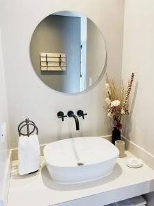 La salle de bains est pourvue d'un lavabo blanc et d'un miroir. dans l'établissement La Morada, à Purmamarca