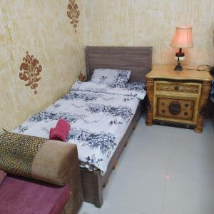 a bedroom with a bed and a table with a lamp at العين الهيلي مصباح بيت 8 in Al Ain