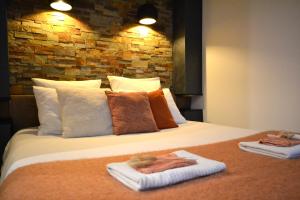 1 dormitorio con 1 cama con toallas en L'Intimiste Balnéo Spa, pure détente et romantisme, en La Richardais
