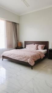 a bedroom with a large bed with pink pillows at Villa Gardenia Pantai Jepara in Jepara