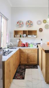 a kitchen with wooden cabinets and plates on the wall at Villa Gardenia Pantai Jepara in Jepara